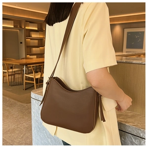 Détail du sac bandoulière vintage en cuir marron avec bandoulière réglable