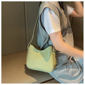 Vue latérale d'un sac à bandoulière vintage vert sauge porté par un mannequin en intérieur