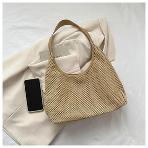Vue de dessus d'un sac à bandoulière en paille tressée avec lanières en cuir sur costume