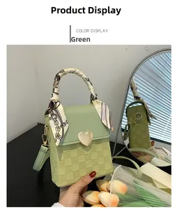 Detail of green mini crossbody bag with heart buckle and silk scarf wrapped handle