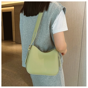 Détail du sac croissant vert clair en cuir lisse avec une large bandoulière réglable