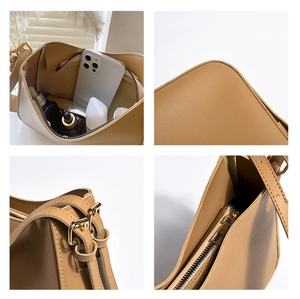 Détail du sac bandoulière camel montrant la grande capacité intérieure et les ferrures dorées