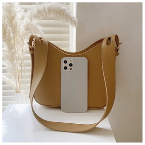 Détail de la capacité d'un sac demi-lune jaune avec un smartphone pour comparer la taille
