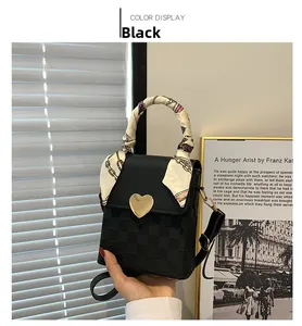 Detail of checkered embossed black crossbody bag with heart clasp and silk handle