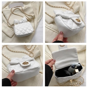 Detailansicht der weißen Mini-Tasche mit Steppung, Goldkette und Schleifendeko