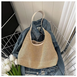 Vue détaillée du sac de plage en paille tressée avec texture fine et bandoulière lisse