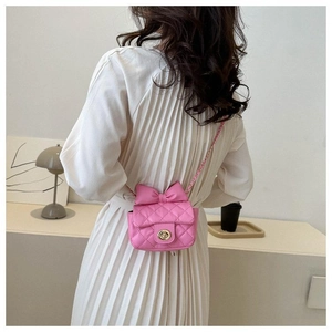 Detail der rosa Mini-Umhängetasche mit Schleife und Steppmuster auf weißem Kleid