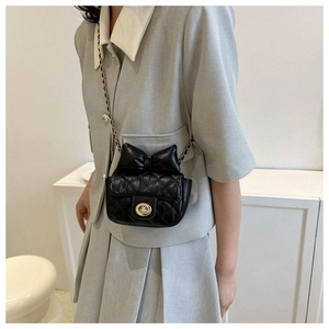 Detail einer Mini-Stepptasche aus Leder mit Schleife und goldener Kette