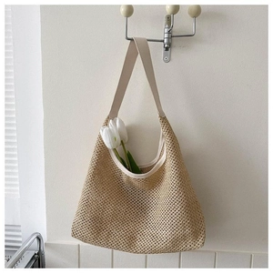 Détail d'un grand sac en paille tissée avec anses en cuir crème et tulipes blanches