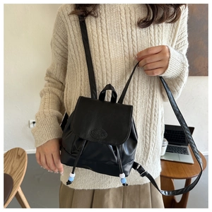 Détail du mini sac à dos en cuir noir avec logo Fashion et fermeture à cordon