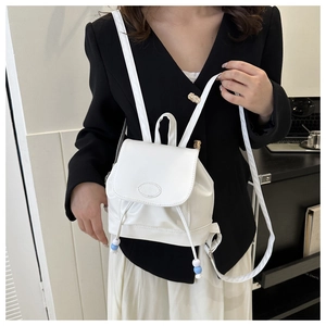 Détail du sac à dos en cuir PU blanc avec cordon de serrage et breloque en perles chic