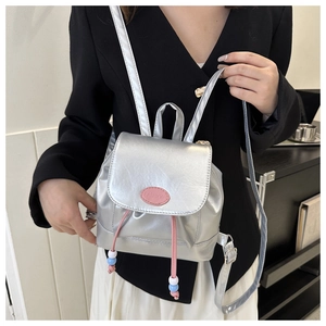Détail du mini sac à dos argenté métallisé avec logo rose et cordon à perles