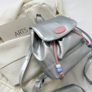 Détail d'un mini sac à dos argenté avec cordon rose et perles de couleur d'accent