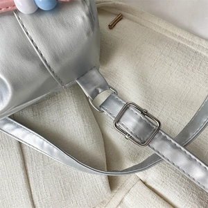 Détail macro du sac en cuir PU argenté avec boucle réglable et perles colorées