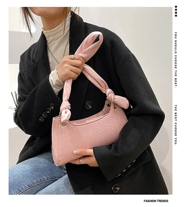 Pink crocodile-embossed faux leather bag featuring a soft knotted handle design