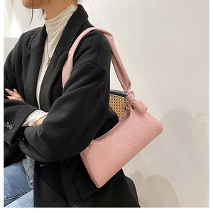 Detail of pink crocodile embossed shoulder bag featuring unique knotted strap design