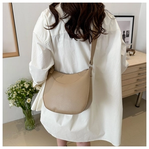 Rear view of khaki saddle bag with pebble leather texture and wide shoulder strap
