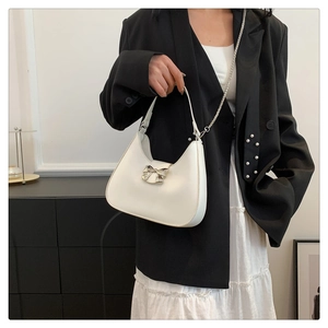 Détail du sac hobo en cuir blanc avec nœud en métal argenté et doubles bandoulières