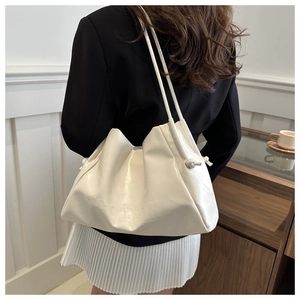 Detail view of white ruched shoulder bag featuring MGCNZHU embossed logo and slim strap