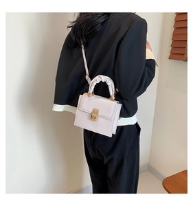 Close-up of stylish lilac crossbody bag with ruched handle and gold metal lock detail