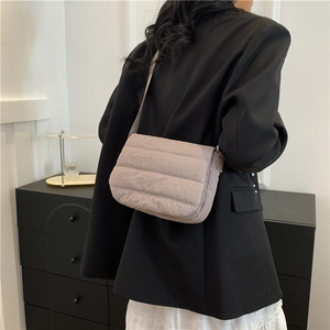 Quilted crossbody bag in light coffee brown shown on model with minimalist style