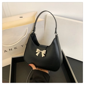 Dettaglio della borsa hobo in pelle nera con fibbia decorativa a fiocco in metallo argento