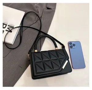 Détail du petit sac carré noir matelassé avec poignée tressée et élément argenté