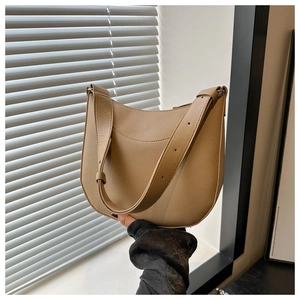 Detail of light brown lychee grain leather texture on minimalist saddle bag with strap