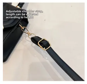 Gros plan sur la bandoulière réglable en similicuir avec boucle dorée du sac noir