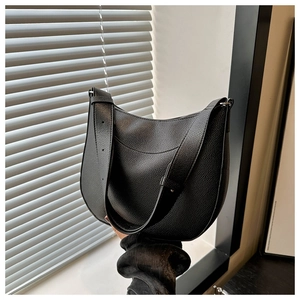 Close-up of black lychee texture leather on a stylish crescent-shaped hobo shoulder bag