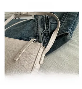 Detailed close-up of cream lychee texture leather shoulder bag with zipper closure