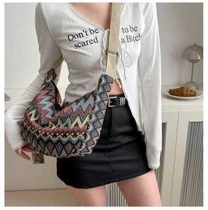 Détail d'un sac bandoulière tissé ethnique avec motifs à vagues colorés et bandoulière large