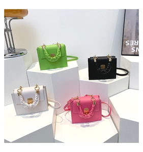 Detailed display of four mini square bags with ruched handles in multiple colors