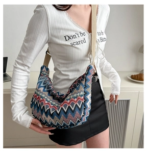 Détail des motifs en chevron colorés sur un grand sac besace bohème en forme de croissant
