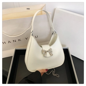 Dettaglio della borsa a mezzaluna bianca con fiocco argento e catena in metallo