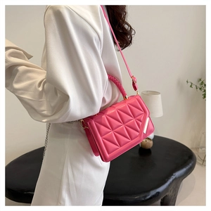 Detail der leuchtend rosa gesteppten PU-Lederhandtasche mit Webgriff und Schultergurt