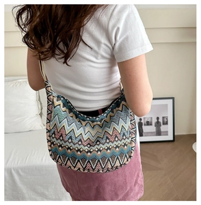 Détail d'un sac bandoulière bohème en tricot zigzag avec des motifs à ondes colorés