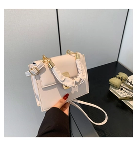 Detail of white PU crossbody bag with pleated handle and golden magnetic buckle
