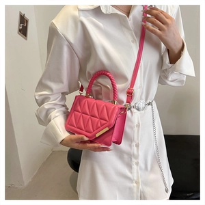 Détail du sac à main matelassé rose avec poignée tressée et boucle dorée chic