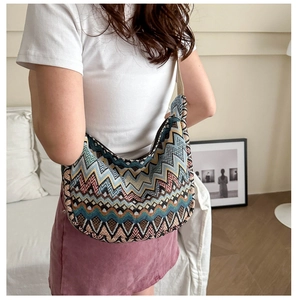 Détail d'un sac à bandoulière tissé avec motifs géométriques chevronnés et texture riche