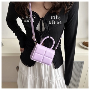 Detail of lavender quilted PU leather handbag featuring a crossbody strap and top handle