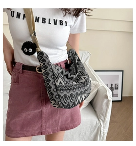 Détail du sac bandoulière demi-lune avec motif ethnique noir et blanc et pompon noir