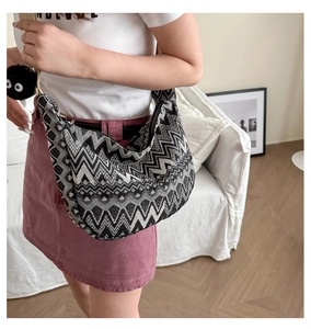 Détail du sac bandoulière tissé à motif zigzag, fermeture éclair et breloque peluche