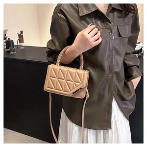 Close-up of beige quilted small crossbody bag with woven handle and sleek metal details