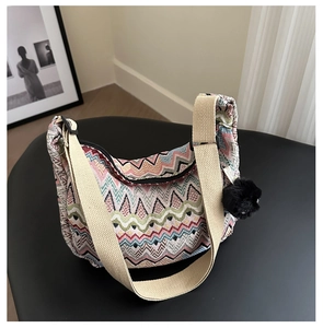 Détail du sac hobo ethnique tissé en zigzag avec pendentif décoratif en boule de peluche