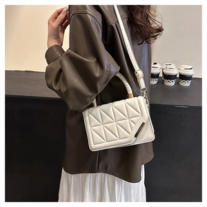 Detail der weißen Stepptasche mit Dreiecksnaht und geflochtenem Griff am Modell