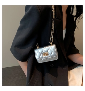 Detail of silver quilted mini chain bag with golden turn-lock and woven strap