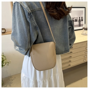 Close-up of beige lychee texture leather crossbody bag shown in a lifestyle setting
