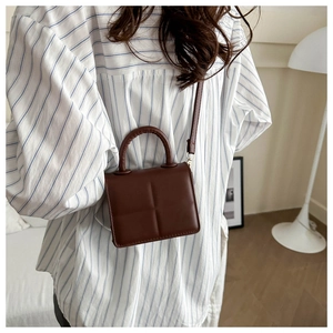 Detail showing the brown PU leather crossbody bag with geometric embossed pattern texture