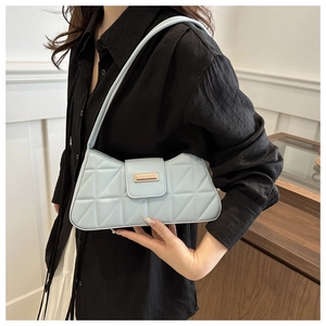Modelo con bolso baguette acolchado azul claro con hebilla metálica dorada rectangular
